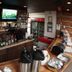 Riverbank Lodge in Petersburg bar area with liquor shelves, TV, cooler, and counter service
