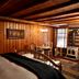 Chalet of Canandaigua room with wood-paneled walls, bed, small dining table, and wood stove