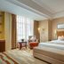 Power Valley International Hotel in Baoding guest room with king bed, bench, armchair, and large window