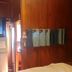 Wood House Pattaya in Pattaya with wood-paneled room, hanging towels, and bed near doorway