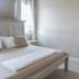 Hotel Whiskey in Pascagoula guest room with bed, nightstand and open doorway to kitchen
