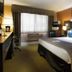 Prospector Hotel & Gambling Hall in Ely guest room with king bed, desk, window AC, and armchair