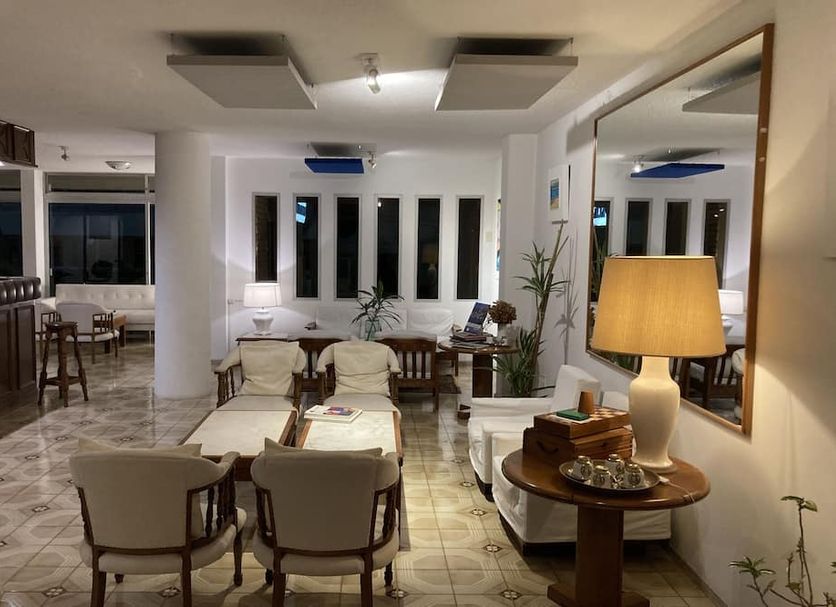 Alhambra Punta del Este lounge with seating area, table lamp, large mirror, and tiled floor