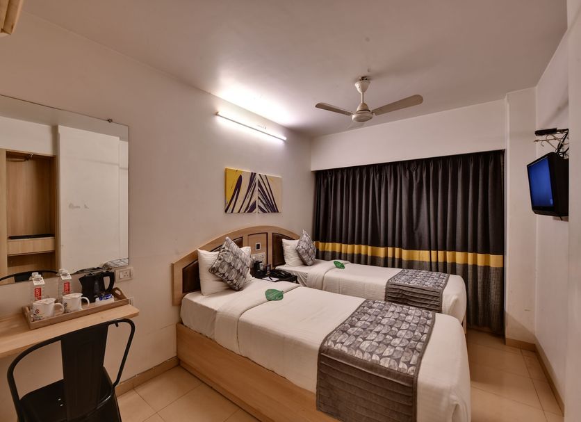 Click Hotel Andheri Midc in Mumbai, twin guest room with two beds, desk, wall mirror, TV and curtain-covered window
