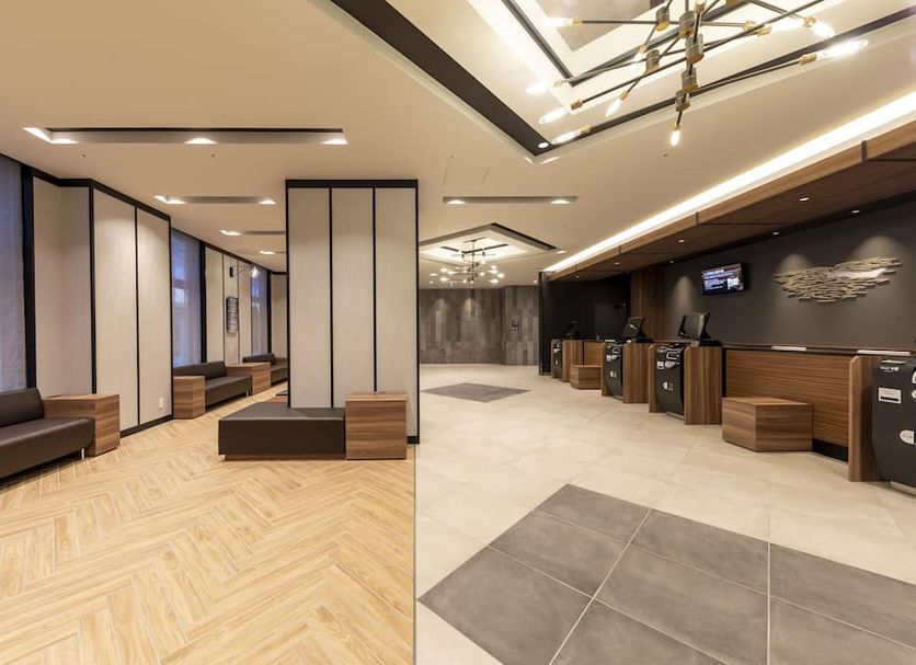 Dormy Inn Kawasaki Natural Hot Spring lobby with seating, reception desks, and modern ceiling lights in Kawasaki