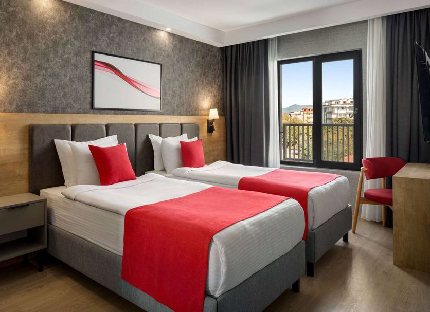 Ramada by Wyndham Dalaman twin room with red accents and balcony view over Dalaman