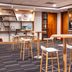 Holiday Inn London - Gatwick Airport By IHG lounge with round tables, stools, and coffee station