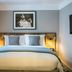 Victory House London guest room with king bed, bedside lamps and framed artwork