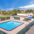 Motel 6 Meridian MS outdoor pool with fenced deck, lounge chairs and blue umbrellas