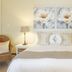 Kingfisher Guesthouse in Port Elizabeth bedroom with king bed, bedside lamps and floral wall art