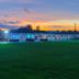 Catalina Airport Motel in Indianapolis at sunset with lit motel buildings and a large green lawn
