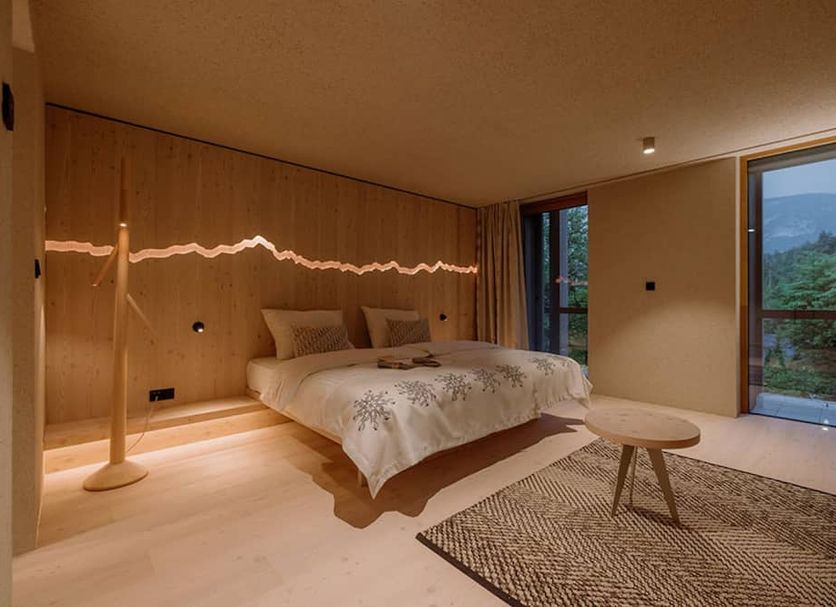 Hotel Bohinj, Ribčev Laz: modern bedroom with wood walls, large windows, mountain views and rug