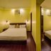 Ganga Beach Resort in Rishikesh, a twin-bedded hotel room with warm yellow walls and wall-mounted lights