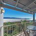 Airlie Apartments in Airlie Beach balcony with glass table, chairs, and ocean view