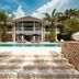 The Ungasan Clifftop Resort in South Kuta with a pool, steps, cabanas and tropical landscaping