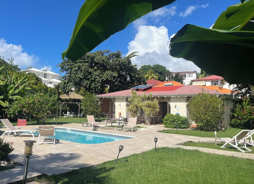 Hôtel Les Bananiers in Le Gosier with outdoor pool, sun loungers and tropical garden