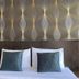 The Singora Hotel in Songkhla bedroom with twin pillows and patterned wall headboard