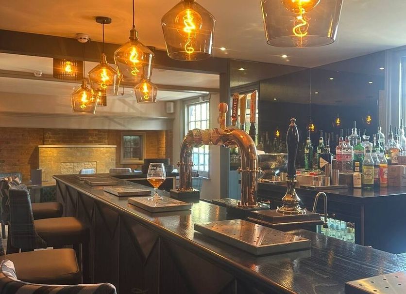 The Boot Inn Worcester bar with hanging pendant lights, polished counter, and stocked bottles