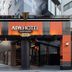 APA HOTEL Kanda Ekimae entrance in Tokyo with orange-and-black facade and covered driveway