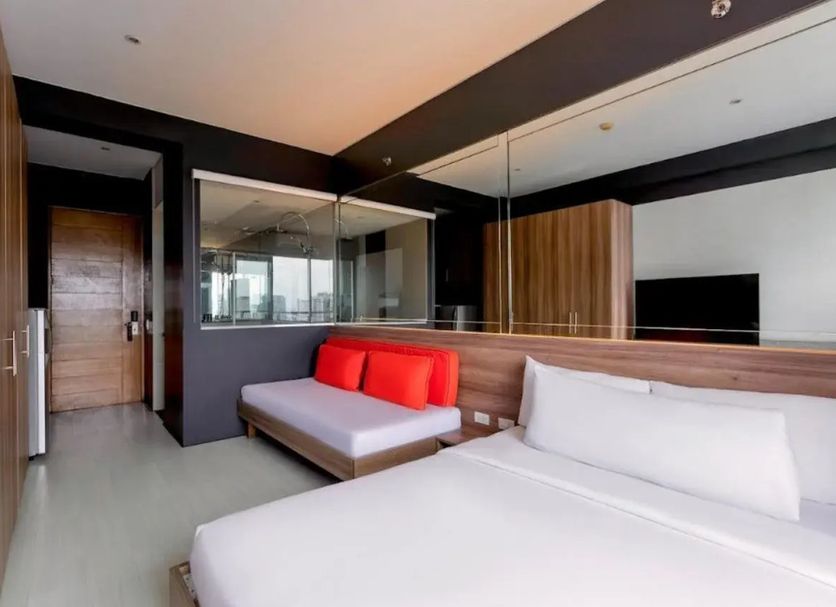 Puerto Caleta in Caleta de Fuste: modern hotel room with twin beds and a bright red sofa