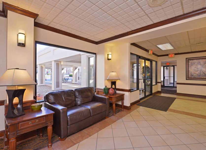 Quality Inn & Suites Williamsport lobby with leather sofa, lamps, tile floor and entrance