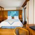 Hotel Restaurant Du Port in Yvoire guest room with double bed, balcony doors and lake view artwork