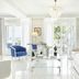 The Danai in Nikiti: bright seaside suite with white sofa, blue chairs, chandelier, and balcony doors