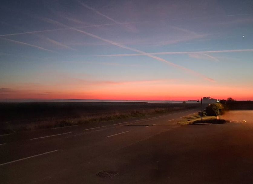 Auberge de la Baie in Pontorson with a sunset sky over a quiet road and open landscape