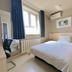 Century Star Urumqi Changjiang Road Hotel room with double bed, window, desk, and wall-mounted air conditioner