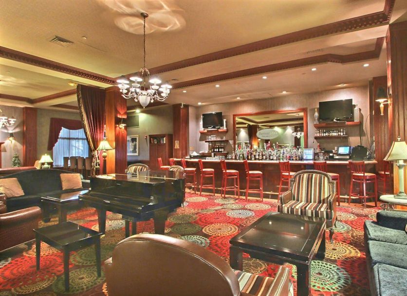 Holiday Inn & Suites Madison West - Middleton by IHG lobby lounge with piano, bar, and colorful carpet
