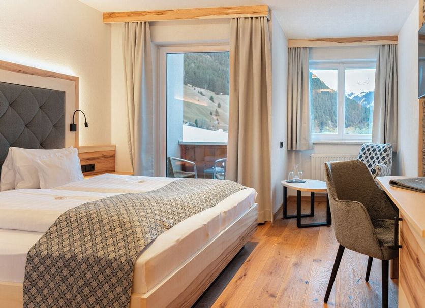 Wohlfühlhotel Berg Heil room in Holzgau with balcony mountain view, bed, desk and seating area