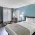 SureStay Plus by Best Western Asheboro guest room with king bed, armchair, lamps and teal walls