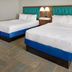Hampton Inn Kansas City The Legends guest room with two queen beds and bedside lamp