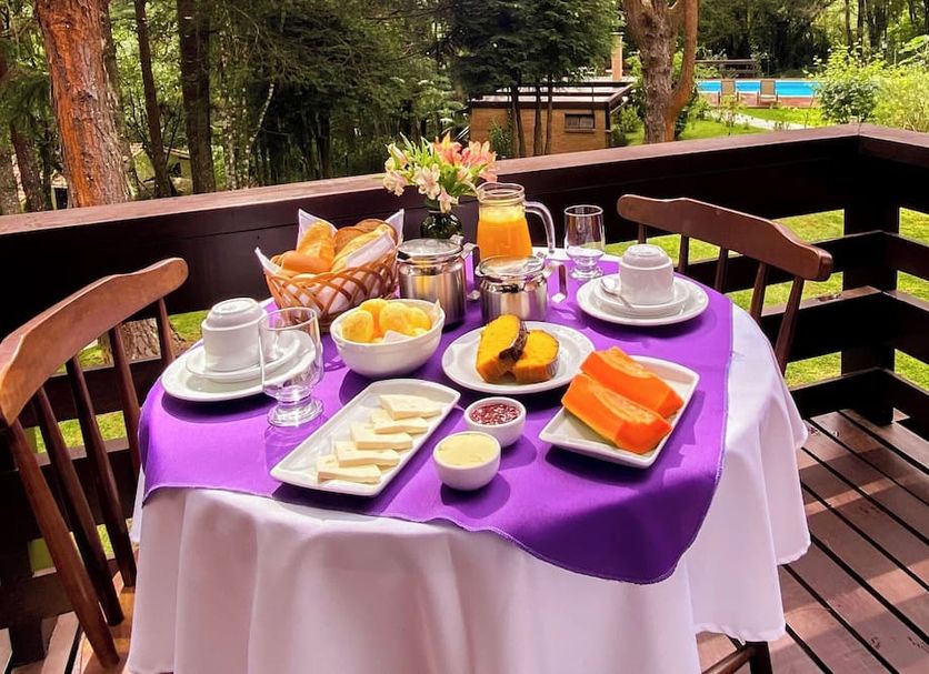 Breakfast table at Pousada O Cantinho da Raposa in Monte Verde on a wooded deck with garden view