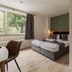 Hotel Enger Hof in Düsseldorf guest room with twin beds, window seating area, and shower alcove