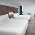 Wingate by Wyndham Sheboygan hotel room with two beds, desk, TV, and city window view