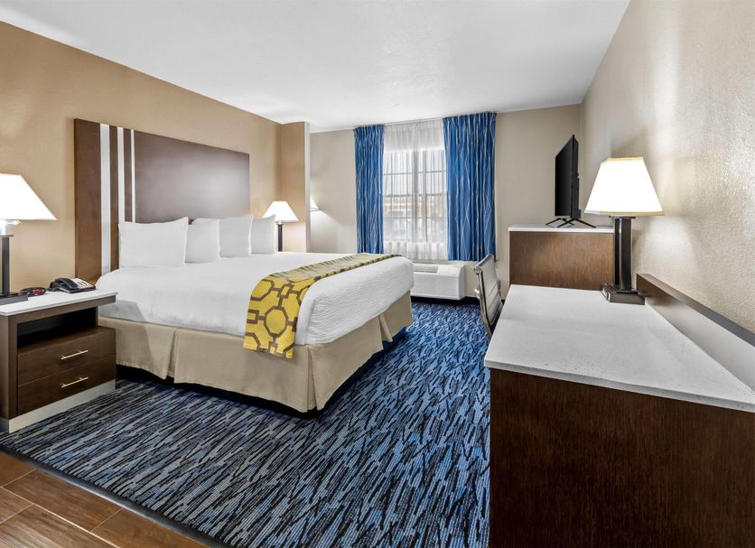 Baymont by Wyndham Port Arthur/Groves Area guest room with king bed, TV, desk and window seating