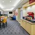 TownePlace Suites by Marriott Tulsa North/Owasso breakfast area with tables, yellow chairs and coffee station in Owasso