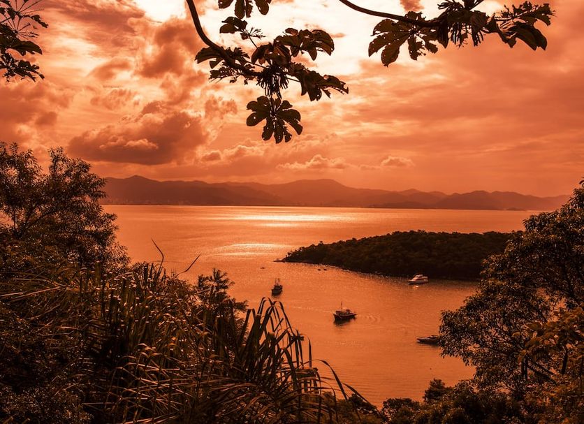 Hotel Itapema Meia Praia in Itapema, with sunset ocean view and small boats by the shore
