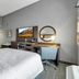 Hampton Inn Buffalo - Amherst guest room with two beds, TV, desk and round mirror in Amherst.