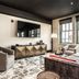 Bottleworks Hotel in Indianapolis guest lounge with sofa, armchairs, wall TV and large windows