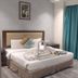 The Platinum Hotel, Hyderabad guest room with king bed, teal curtains, and chair by the window