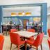 Comfort Inn and Suites Brighton Denver NE Medical Center dining area with orange chairs and bar seating in Brighton