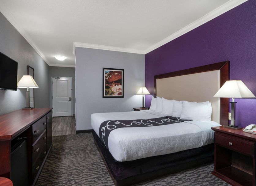 La Quinta Inn & Suites by Wyndham Loveland/Estes Park guest room with king bed and purple accent wall