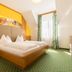 Thermenhotel Kurz in Lutzmannsburg guest room with double bed, green carpet, and tall window