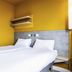 Hôtel ibis budget Fontainebleau Avon room with twin beds, yellow walls and gray headboard in Avon