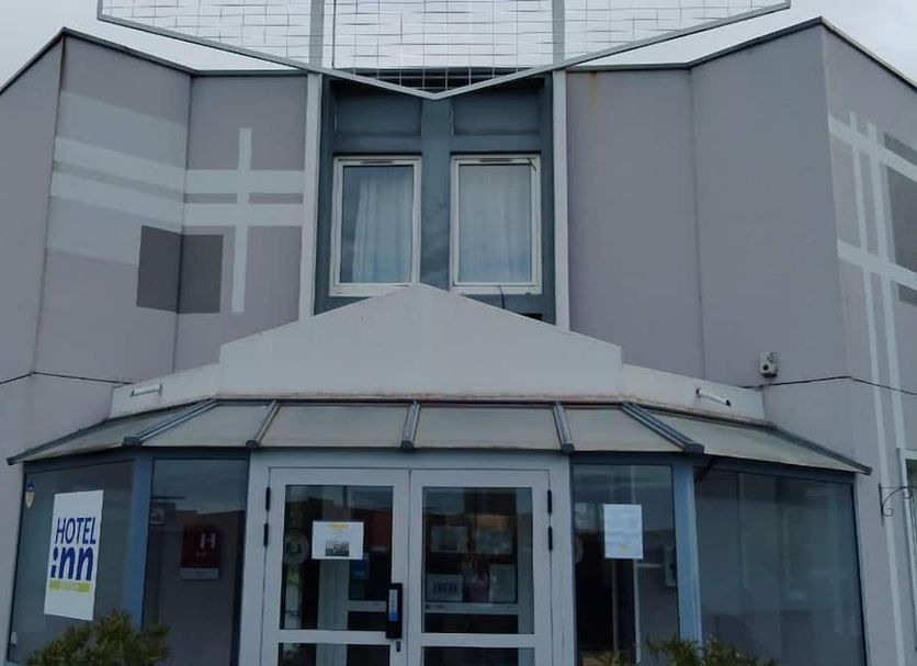 B&B HOTEL Montluçon exterior entrance with glass doors and modern gray facade
