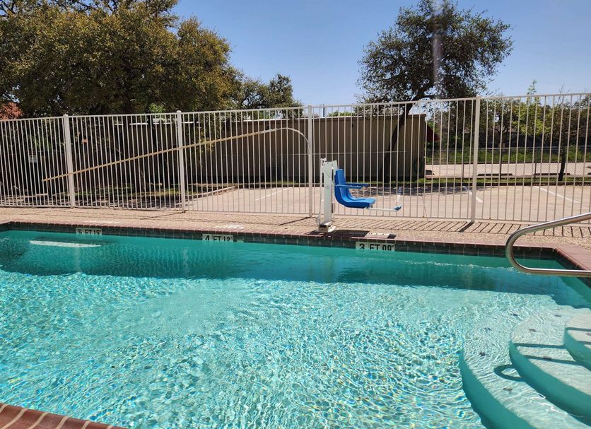 Baymont by Wyndham San Antonio Airport pool with clear water, fence, and pool steps in San Antonio