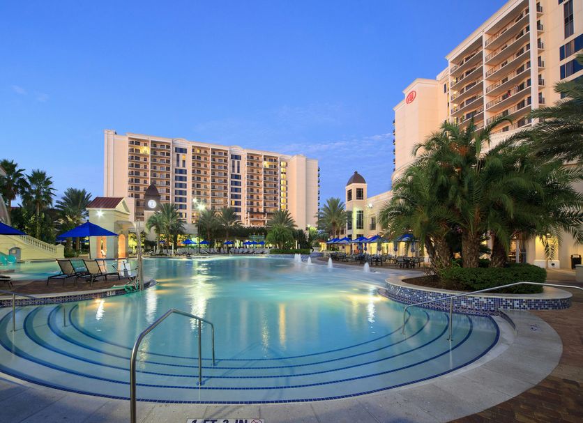 Hilton Grand Vacations Club Parc Soleil Orlando pool at dusk with palm trees and resort towers