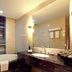 Huihao Hotel Wuhan bathroom with soaking tub, double vanity, and large mirror